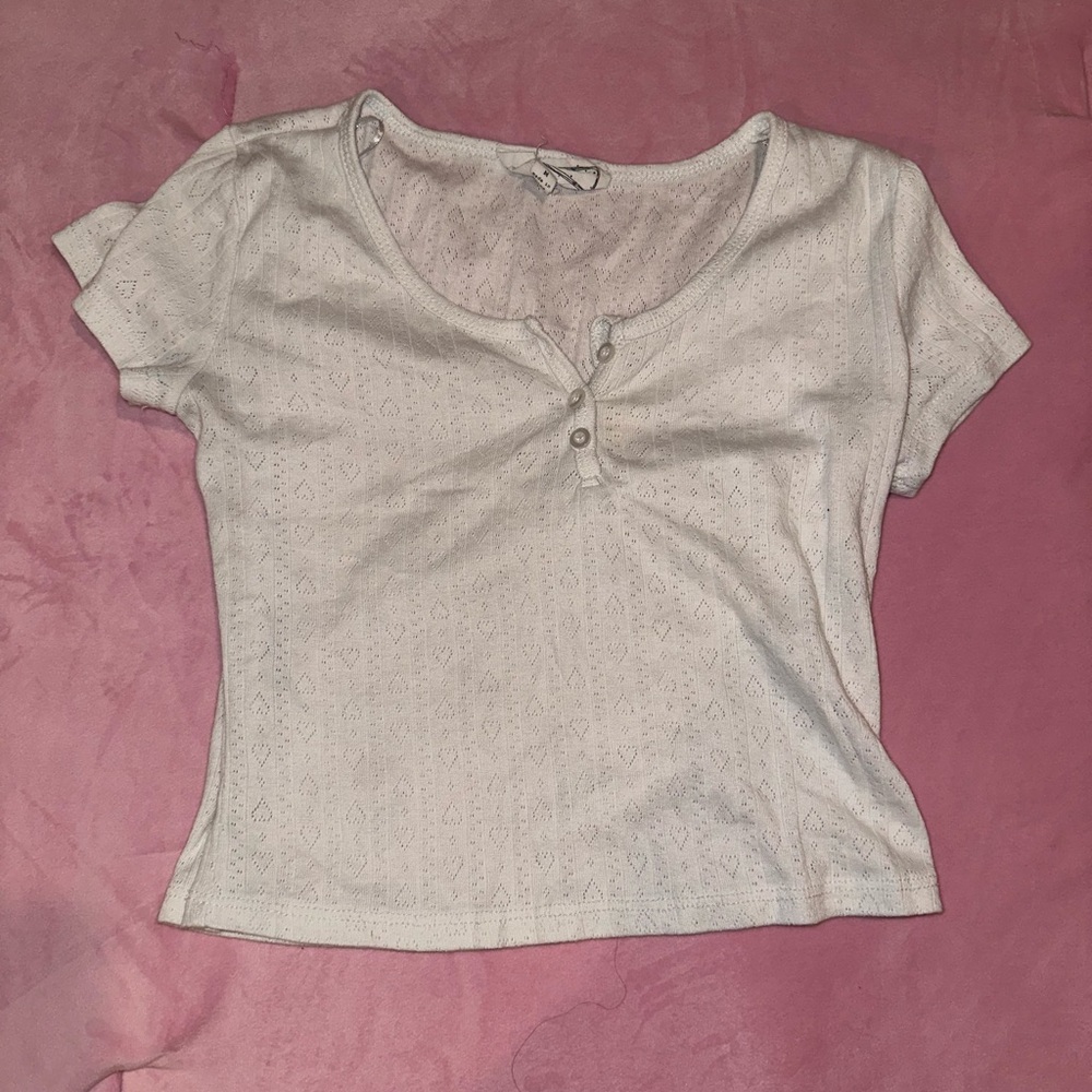White crop top with coquette heart and ribbed pattern.